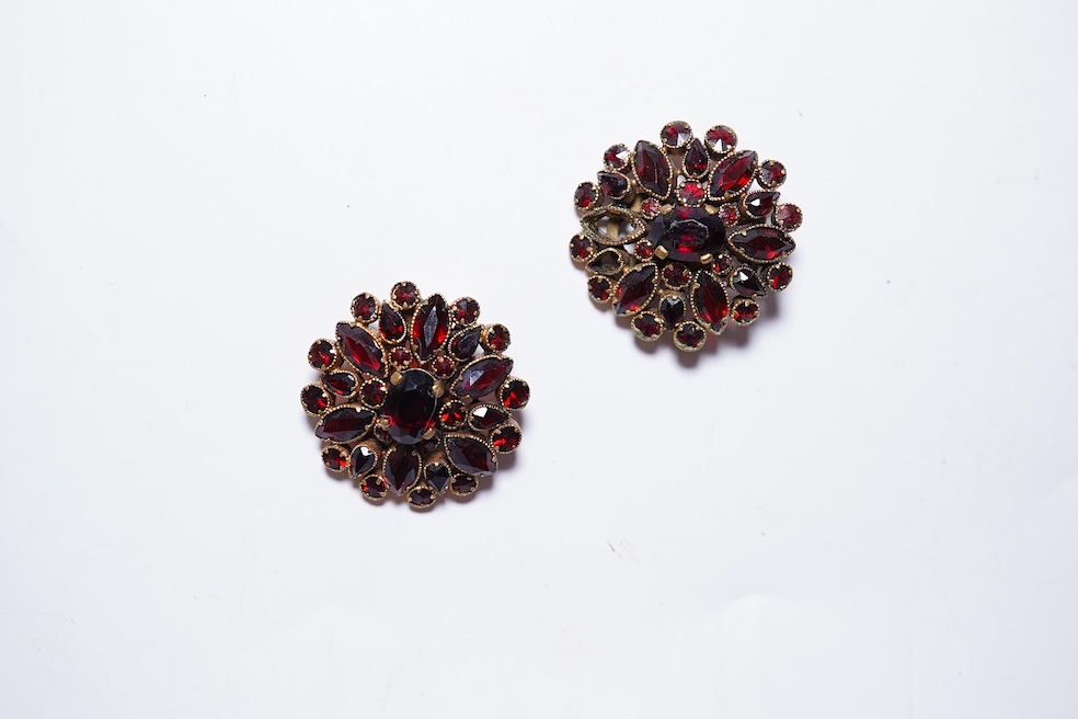 A suite of garnet and paste jewellery, comprising: a brooch, 5cm diameter; a bangle, inner circumference 16cm; two rings, sizes I and M; a pair of earrings, and a single earring, each set with rose-cut garnets; and a pai